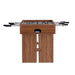 Walnut Wood Crate & Barrel Modern Wood Foosball Table seen from the end with the chrome rods extending out both sides and an oval ball return opening in the end panel