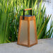 Weathered Teak Crate & Barrel Les Jardins Roam Teak LED Outdoor Solar-Powered Lantern 16" shown in a styled outdoor setting, a tapered teak lantern with frosted panels