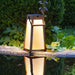 Weathered Teak Crate & Barrel Les Jardins Roam Teak LED Outdoor Solar-Powered Lantern 16" shown in a styled outdoor setting, its solar panel set into the top of the frame