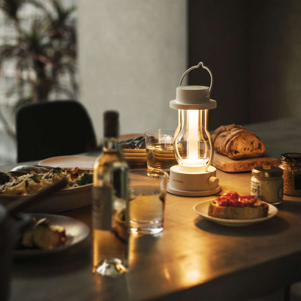 White Crate & Barrel Balmuda LED Rechargeable Outdoor Lantern shown on a plain background, a cordless lantern with a metal carry handle