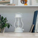 White Crate & Barrel Balmuda LED Rechargeable Outdoor Lantern shown on a plain background, a dimmable lantern with an adjustable color temperature knob