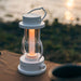 White Crate & Barrel Balmuda LED Rechargeable Outdoor Lantern shown on a plain background, a lantern with a candle flicker setting from 1,600K to 3,000K