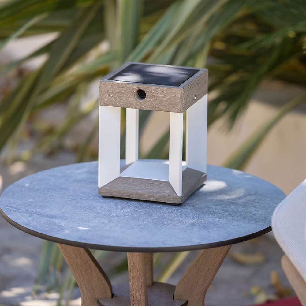 White Crate & Barrel Blade White Metal LED Solar Outdoor Table Lamp in white-finished aluminum and weathered teak with an integrated solar panel and dimmable LEDs, shown in the first alternate view