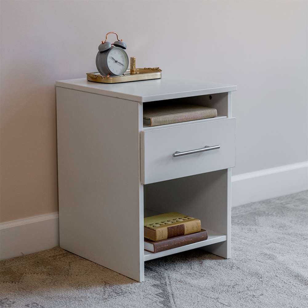 White Inovabed Wall Bed with Sofa and Two Nightstands showing one nightstand at an angle topped with an alarm clock on a brass tray, with books on the lower shelf