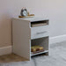 White Inovabed Wall Bed with Sofa and Two Nightstands showing one nightstand at an angle topped with an alarm clock on a brass tray, with books on the lower shelf