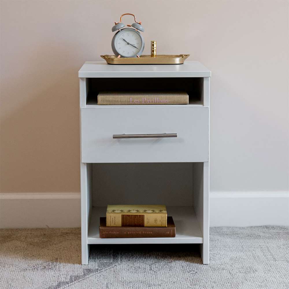 White Inovabed Wall Bed with Sofa and Two Nightstands showing one nightstand head-on topped with an alarm clock on a brass tray, with books on the lower shelf