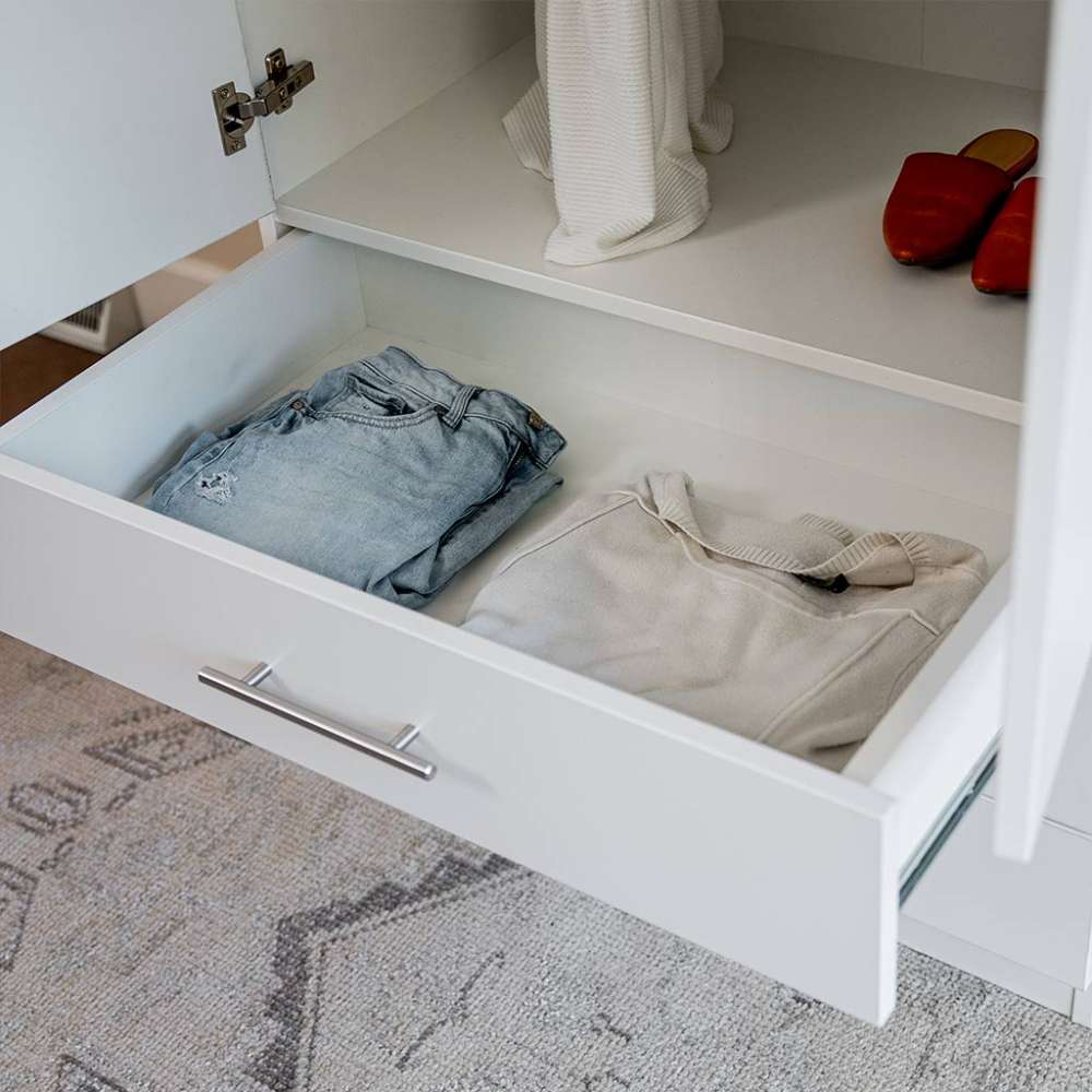White Inovabed Wall Bed with Sofa and Wide Flex Cabinet in close-up with a Wide Flex Cabinet drawer pulled open on folded clothes, with red shoes on the shelf above