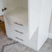 White Inovabed Wall Bed with Sofa and Wide Flex Cabinet showing the lower half of the Wide Flex Cabinet with one door open beside the three drawers