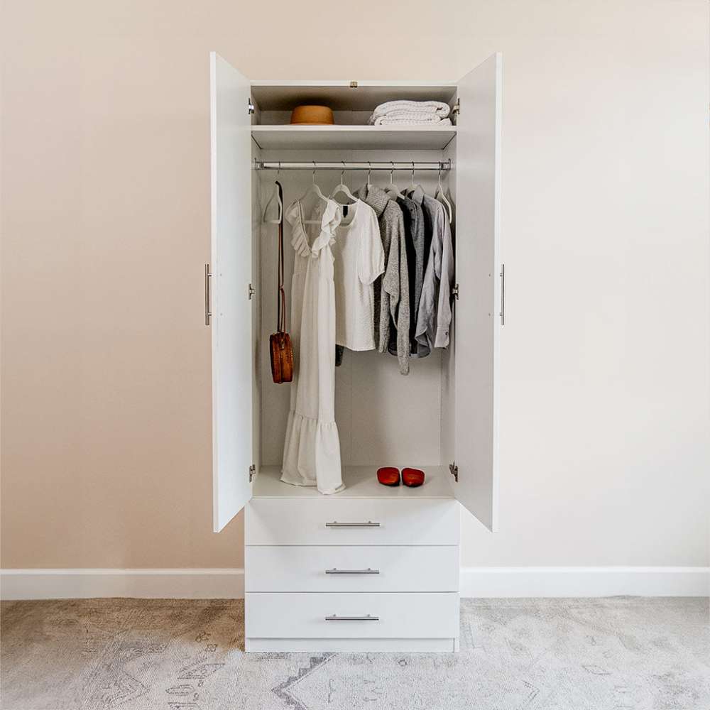 White Inovabed Wall Bed with Sofa and Wide Flex Cabinet showing the Wide Flex Cabinet open in a room with clothes hanging on the rod, folded items on the top shelf and red shoes on the base