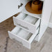 White Inovabed Wall Bed with Table and Two Narrow Flex Cabinets in close-up with two Narrow Flex Cabinet drawers pulled open on folded towels and a hat resting above