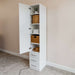 White Inovabed Wall Bed with Table and Two Narrow Flex Cabinets showing one Narrow Flex Cabinet open and styled with woven baskets, folded towels, a hat and a small plant