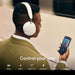 White Sonos Ace Wireless Headphones with Noise Cancellation seen from behind on a man holding a phone with the words Control your way and a row of icons captioned Dolby, Rapid, USB-C, Bluetooth, Wear and Apple