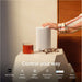 White Sonos Era 100 Next-Gen Smart Speaker a hand touching the speaker top on a bedside table with the words Control your way and icons for Sonos App, Touch Controls, Apple AirPlay 2, Sonos Voice Control, Amazon Alexa and Direct Control