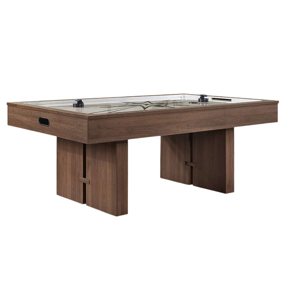 Woodgrain Crate & Barrel Air Hockey Table at a three quarter angle on a white background with the cream playing field, grey starburst print, two black strikers and an oval goal opening in the end panel