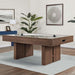 Woodgrain Crate & Barrel Air Hockey Table at an angle in a furnished game room on a pale grey rug over a wood floor, with a large plant, a blue sideboard and two framed artworks behind