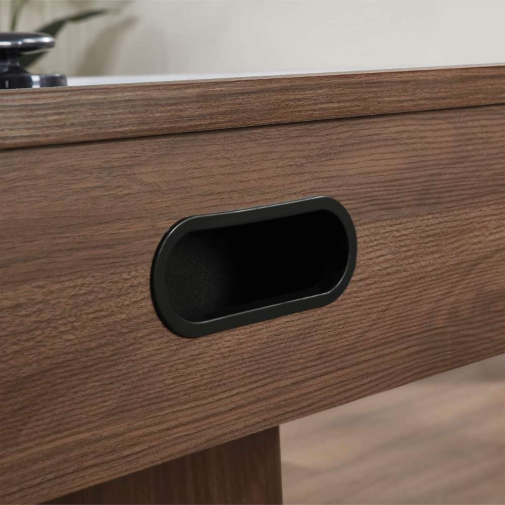 Woodgrain Crate & Barrel Air Hockey Table in tight close up on the black oval goal opening set into the woodgrain end panel