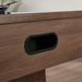 Woodgrain Crate & Barrel Air Hockey Table in tight close up on the black oval goal opening set into the woodgrain end panel